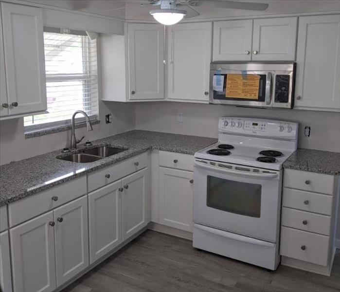 kitchen with white cabinets and appliances and grey floor